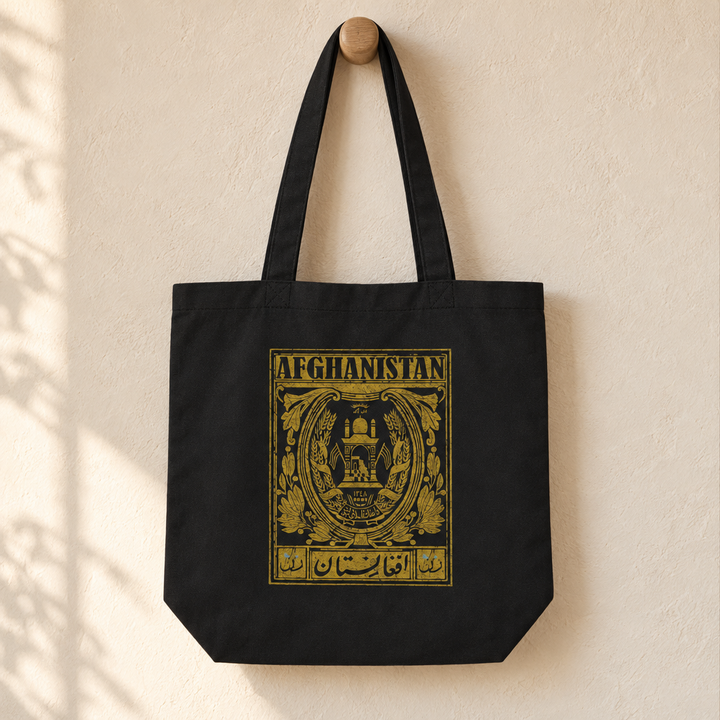 Afghanistan Postcard Tote Bag, hanging from a wooden peg with the printed front visible.