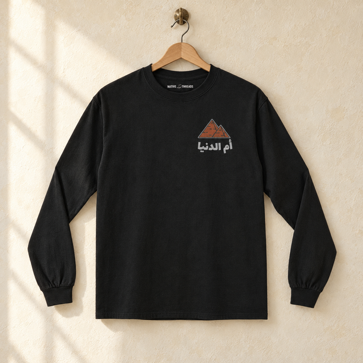 Egypt Umm El Dunya Long Sleeve, hanging on a wooden hanger against a pale wall.