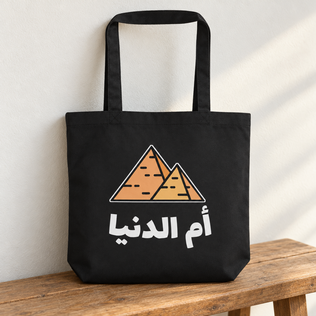 Egypt Umm El Dunya Tote Bag, standing on a wooden bench with the printed front visible.