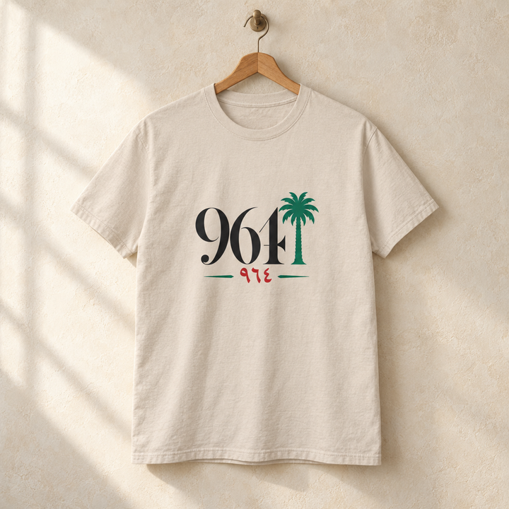 Iraq Date Palm Area Code T-shirt, hanging on a wooden hanger against a pale wall.