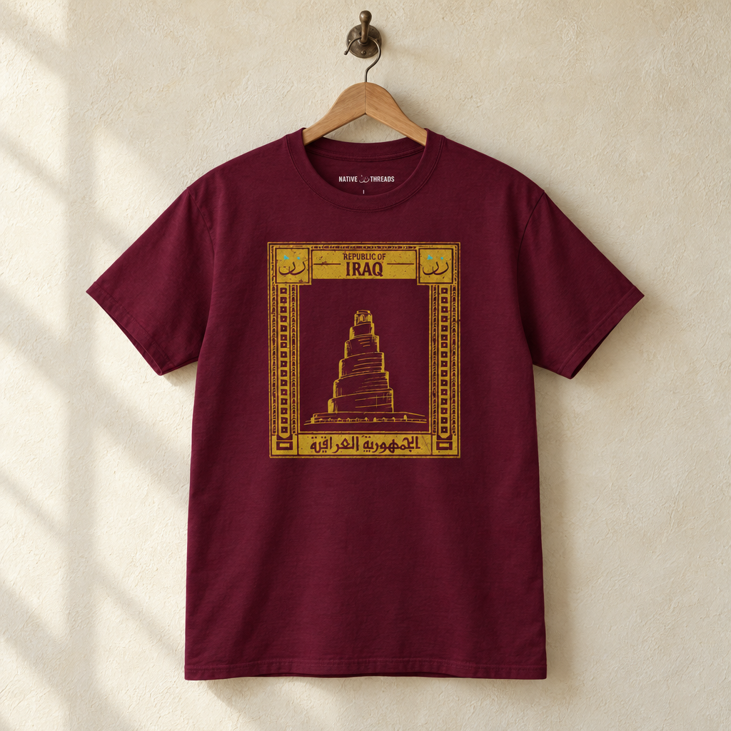 Iraq Postcard T-shirt, hanging on a wooden hanger against a pale wall.