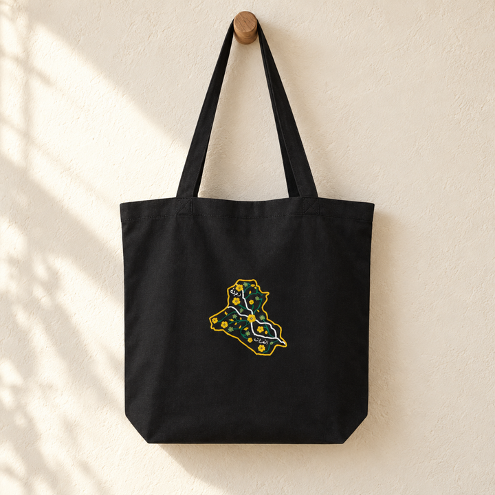 Iraq Tote Bag, hanging from a wooden peg with the printed front visible.