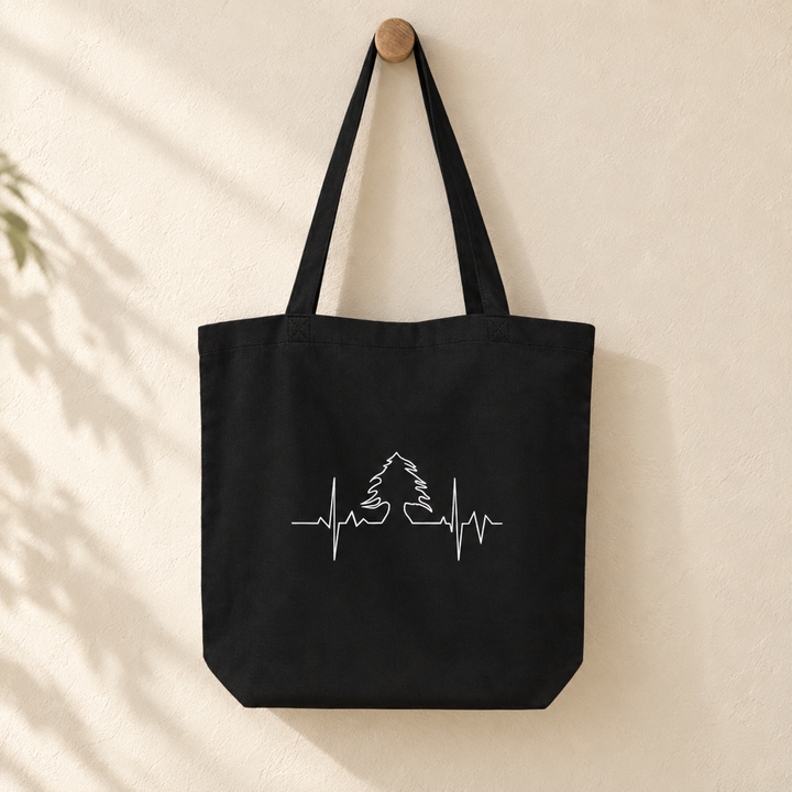 Lebanese Heart Beat Tote Bag, hanging from a wooden peg with the printed front visible.
