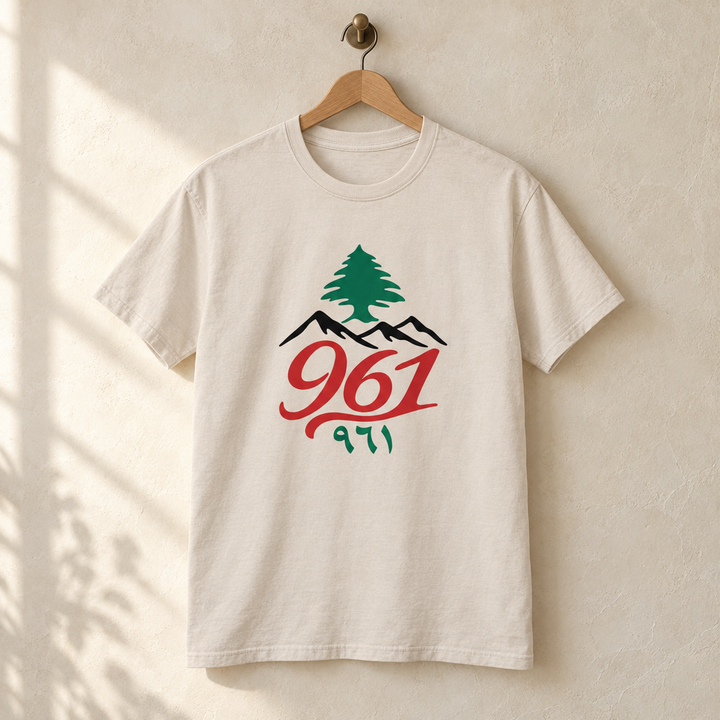 Lebanon Cedar Tree Area Code T-shirt, hanging on a wooden hanger against a pale wall.