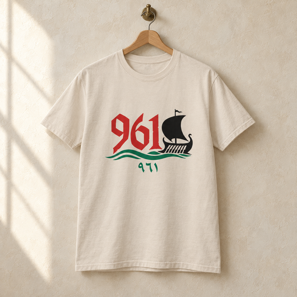 Lebanon Phoenician Ship Area Code T-shirt, hanging on a wooden hanger against a pale wall.