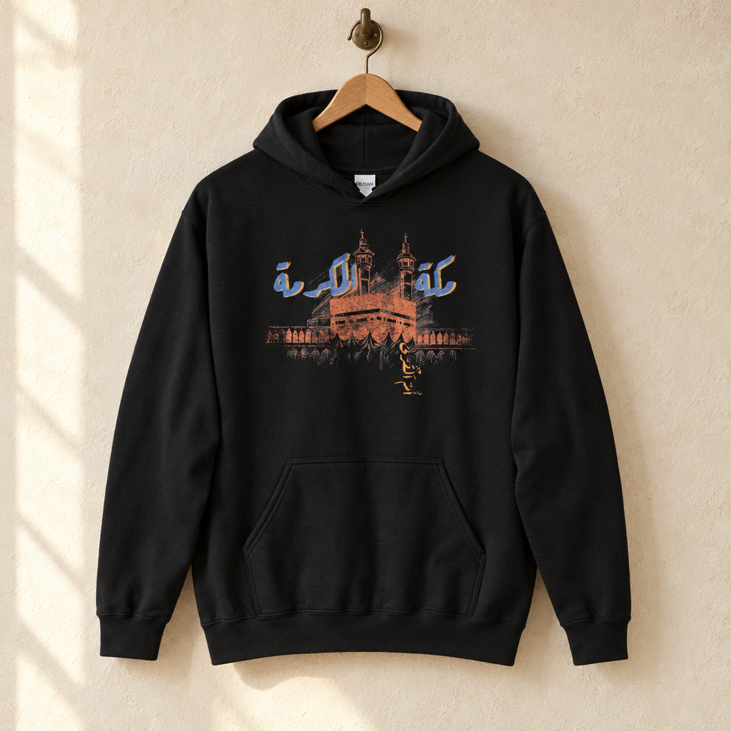 Makkah al-Mukarramah Hoodie, hanging on a wooden hanger against a pale wall.