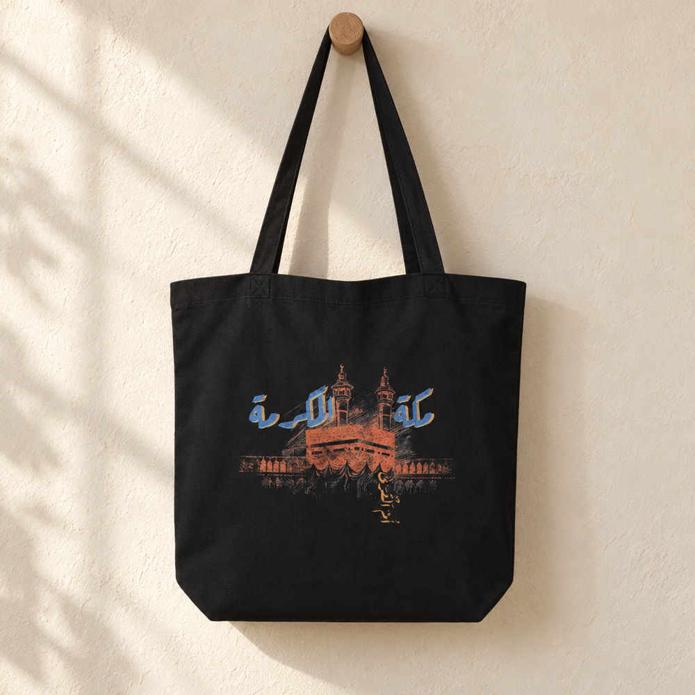 Makkah al-Mukarramah Tote Bag, hanging from a wooden peg with the printed front visible.