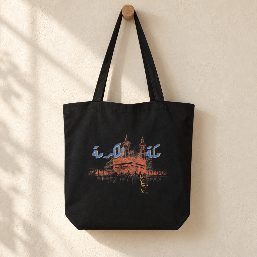Makkah al-Mukarramah Tote Bag, hanging from a wooden peg with the printed front visible.