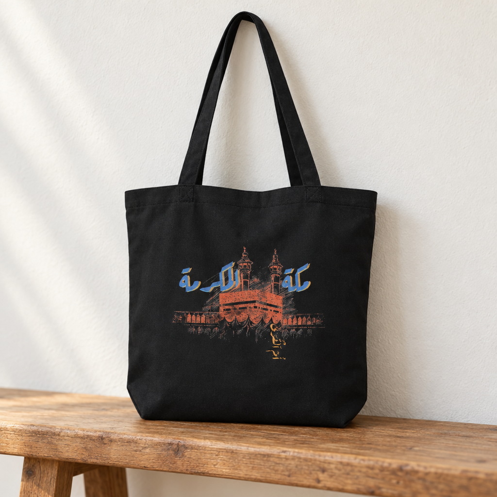 Makkah al-Mukarramah Tote Bag, standing on a wooden bench with the printed front visible.