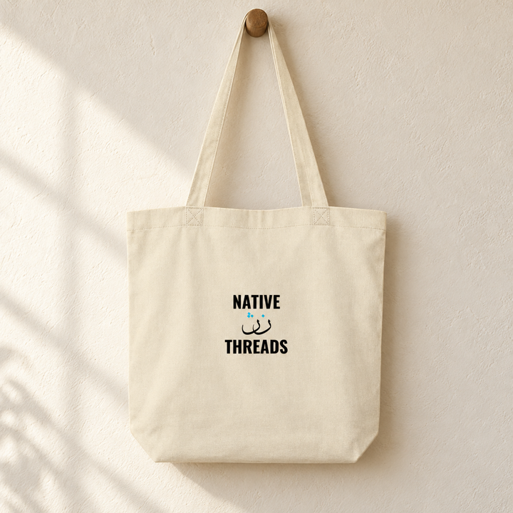 Native Threads Tote Bag, hanging from a wooden peg with the printed front visible.
