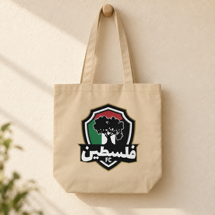 Palestine FC Eco Tote Bag, hanging from a wooden peg with the printed front visible.