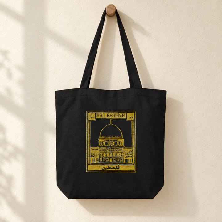 Palestine Postcard Tote Bag, hanging from a wooden peg with the printed front visible.