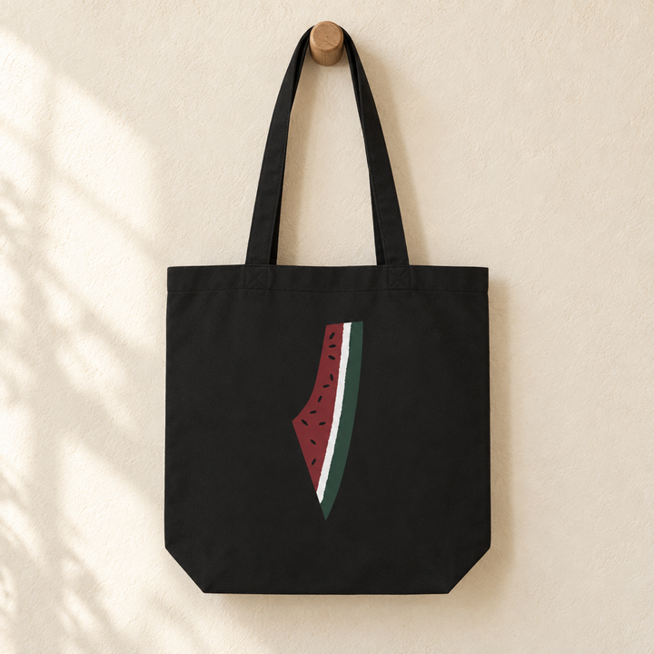 Palestine Watermelon Map Tote Bag, hanging from a wooden peg with the printed front visible.