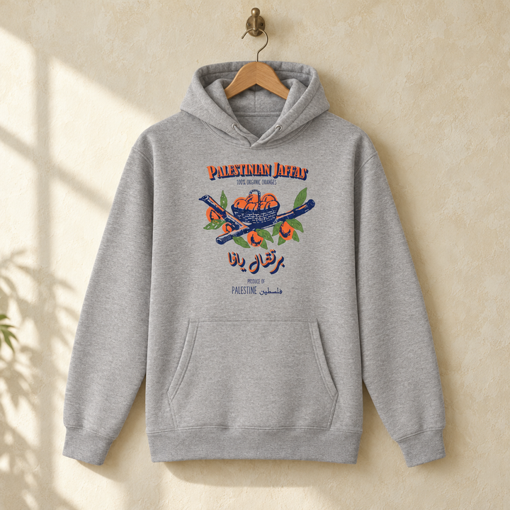 Palestinian Jaffas Hoodie, hanging on a wooden hanger against a pale wall.