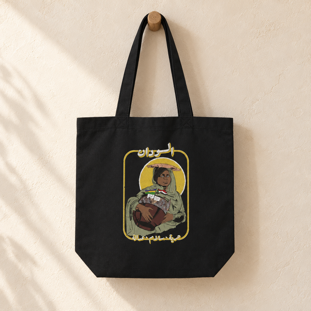 Sudan Revolution Tote Bag, hanging from a wooden peg with the printed front visible.