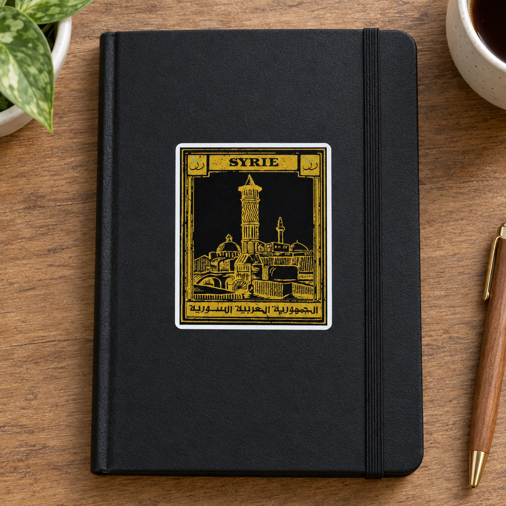 Syria Postcard Sticker, applied to a plain notebook on a desk.