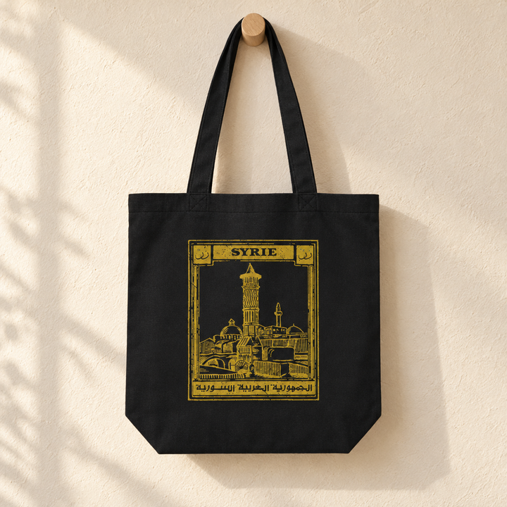Syria Postcard Tote Bag, hanging from a wooden peg with the printed front visible.