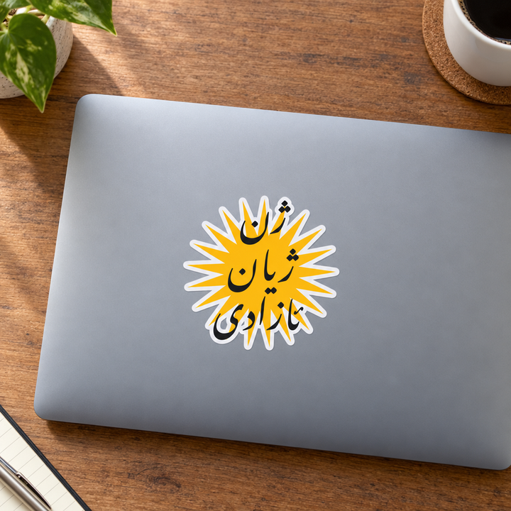 Woman, Life, Freedom Sticker, applied to a closed laptop on a desk.